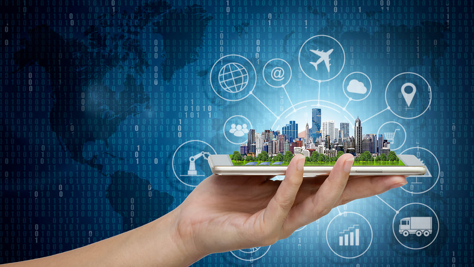 Hand holding smartphone with a 3D city skyline, representing smart city technology and digital connectivity.